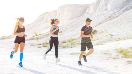 Group of runners run outdoors along the white cliff