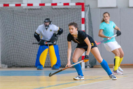 Young female hockey player in defence at the indoor hockey matchの写真素材