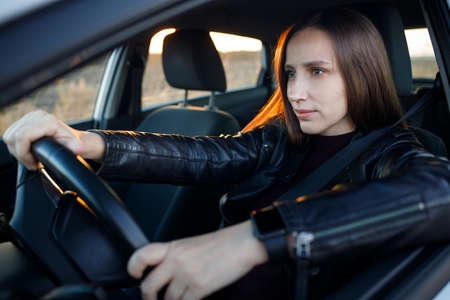 Attentive and stylish female driver in the car.の写真素材