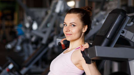 Portrait of young sporty woman in the gym. Smiling girl in the fitness clubの写真素材