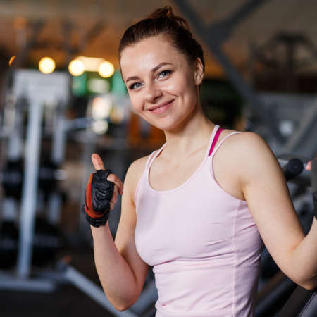 Portrait of young sporty woman in the gym. Smiling girl in the fitness clubの写真素材