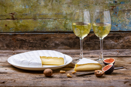 Soft french cheese with white mold Brie with glasses of white wine on the tableの写真素材