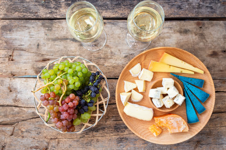 Top view cheeseboard with glasses of wine and grapes on the tableの写真素材