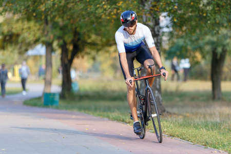Young biker riding bicycle on training in the park.の写真素材