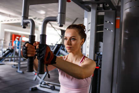 Young fitness woman working out in gym training her chest musclesの写真素材