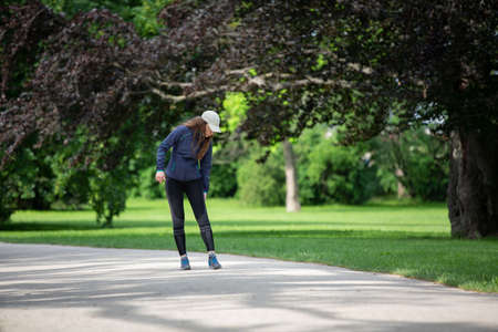 Young jogger woman feeling pain in her leg or kneeの写真素材
