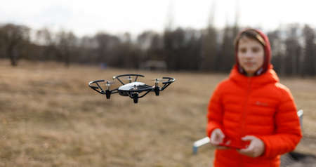 Teenage boy flying small drone in the park