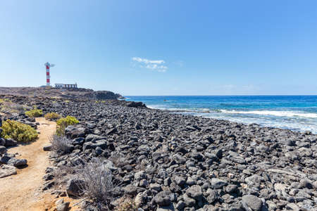 Volcanic ocean shore near lighthouse on Tenerife