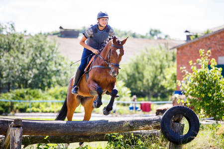 Rider jumps horse over log on cross-country courseの写真素材