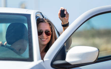 Young happy driver woman with car key in her handの写真素材