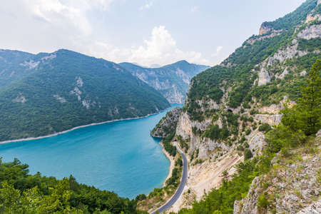 Landscape with big lake in mountains and road along.の写真素材