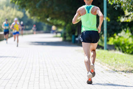 Young fit man running in the park on summer day.の写真素材
