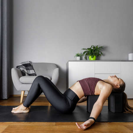 Young yogi woman practicing yoga at home. Heart opening stretching fitness relaxing pose. Image with copy space.の写真素材