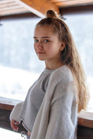 Portrait of young teenage girl in warm cozy clothes at the terrace.の写真素材