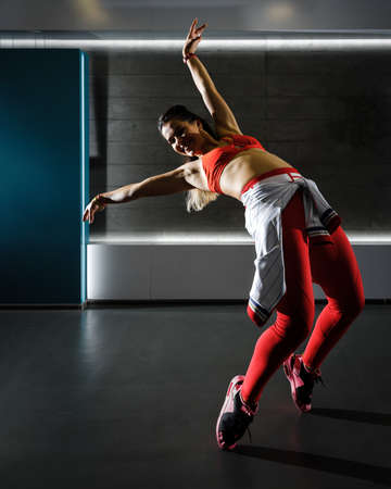 Young active fit woman dancing on the floor in the gym.の写真素材