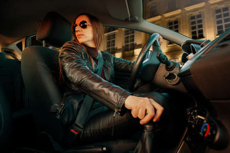 Young woman in stressful situation driving car in the city.の写真素材