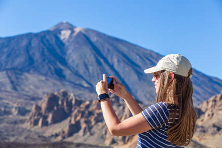 Young tourist woman looking at volcano Teide on Tenerife, Spainの写真素材
