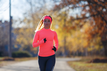 Young fitness woman running on the road in the cold morning in winter.の写真素材