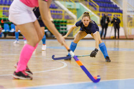 Young hockey player girl in defence against attack in indoor hockey gameの写真素材