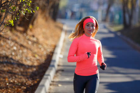 Close up portrait of young running woman in park in frosty morningの写真素材