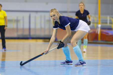 Young woman hockey player playing indoor hockeyの写真素材