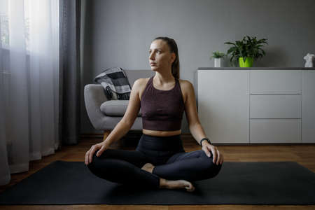 Young woman doing yoga meditation routine in the morningの写真素材