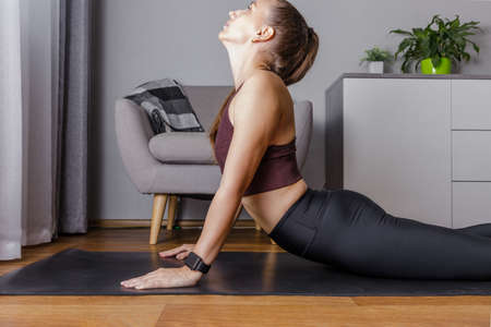Young woman practicing yoga at home in the morningの写真素材