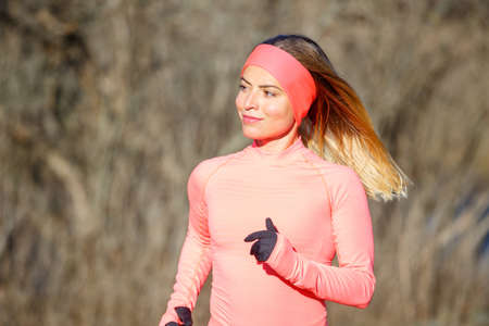 Close up portrait of young running woman in park in frosty morningの写真素材