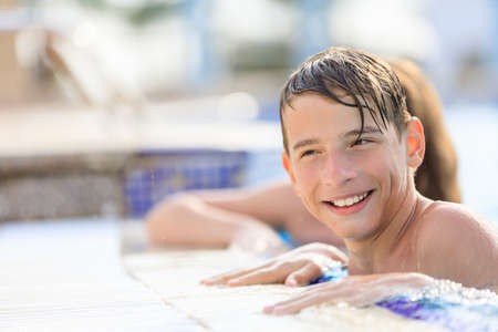 Young boy having fun in the resort pool on vacationの写真素材