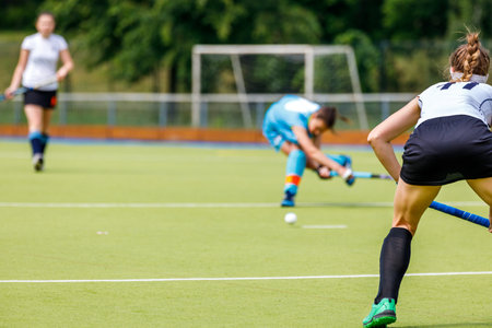 Young woman field hockey player in defense position on the gameの写真素材