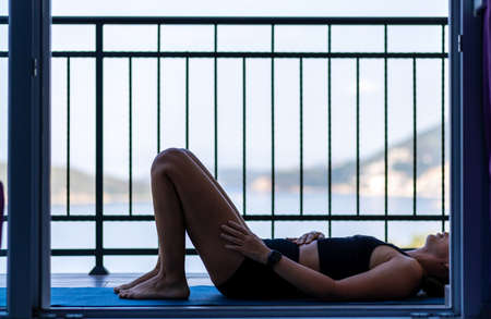 Young woman doing her morning exercise routine at the balcony in the morningの写真素材