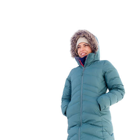 Young woman in warm coat with hood standing isolated on white background.