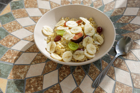 Oatmeal cereal bowl with banana, grapes and the cup of coffee. Top view image of breakfastの写真素材