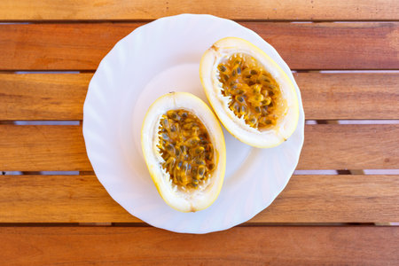Top view of cut in half passion fruit served on white plateの写真素材