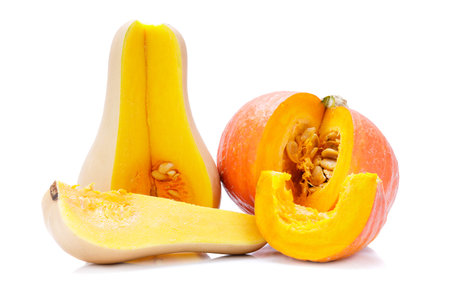 Two small orange pumpkin with cut wedges isolated on white background.の写真素材
