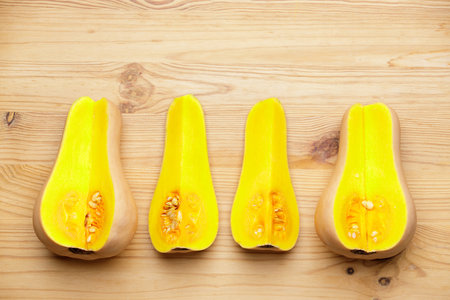 Top view of small orange pumkins cut in wedges on wooden backgroundの写真素材