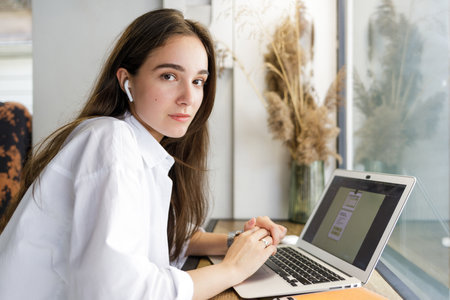 Young woman in white shirt using her laptop for online educationの写真素材