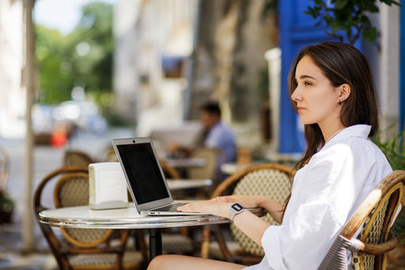 Young woman in white shirt using her laptop for online educationの写真素材