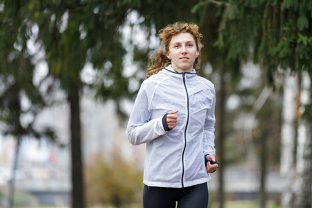 Young woman running in the park in the morningの写真素材