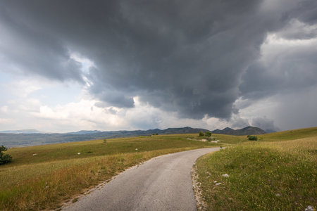 Road trip to the highland with stormy clouds in the skyの写真素材