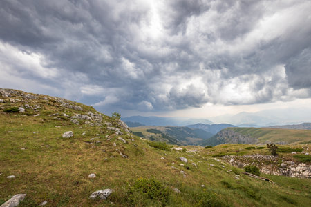 Highland landscape with green grass and stormy weather and heavy cloudsの写真素材