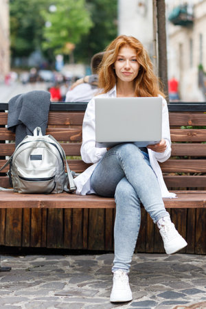 Young attractive woman using laptop and looking into the cameraの写真素材