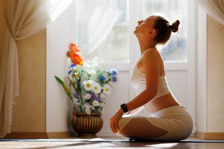 Fitness woman in white sportswear doing breathing on the mat in the morning.の写真素材