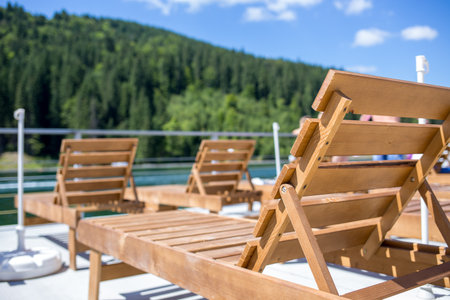 Rows of chaise-lounges at mountain resort near the lake at sunny dayの写真素材