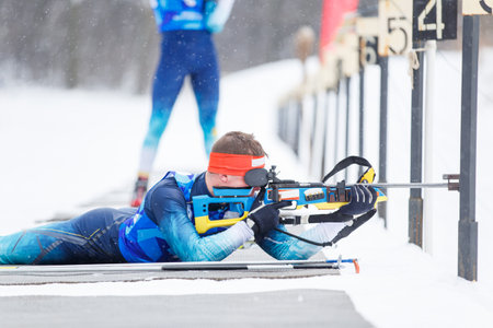Athlete shooting in prone position at the range in a biathlon competitionの写真素材