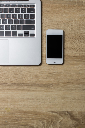 Open notebook and smartphone on wooden background, top viewの写真素材