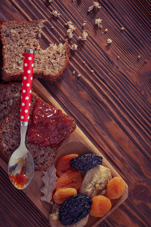 Wholemeal bread with apricot jam surrounded by dry fruit. Vintage/Retro style.の写真素材