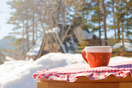 Cup of coffee on wooden bench outdoor in winterの写真素材