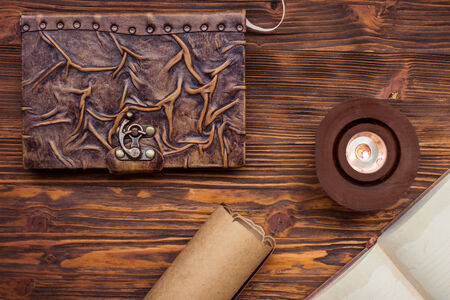 Old book, candle and letter on wooden tableの写真素材