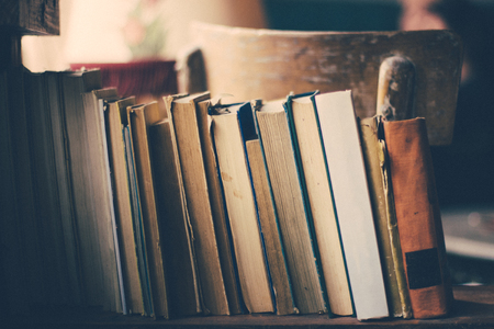 Old books in library shelf.Retro filter, gran added.の写真素材